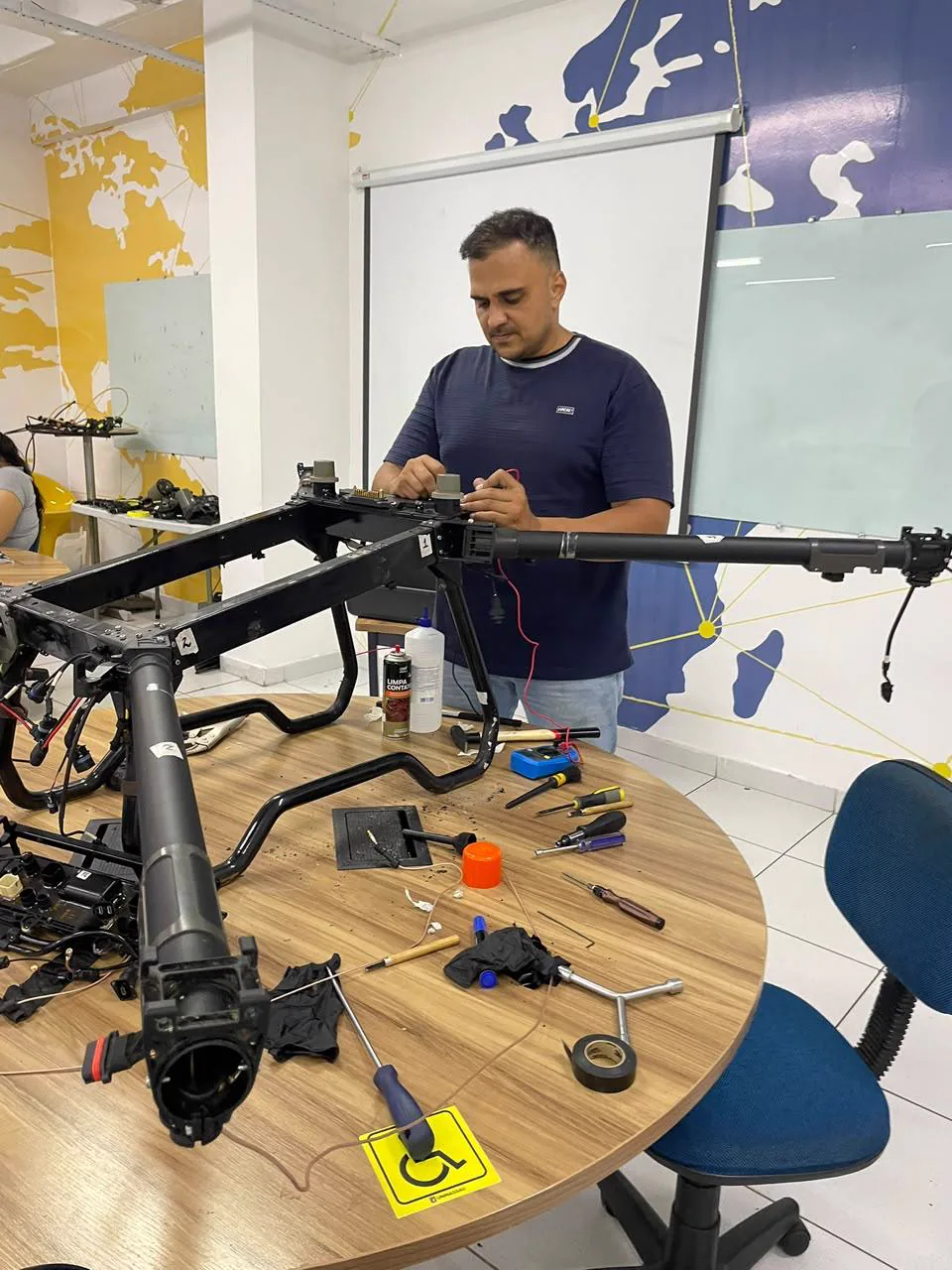 Integrante ligado à Caroá trabalhando em componentes de um drone agrícola.